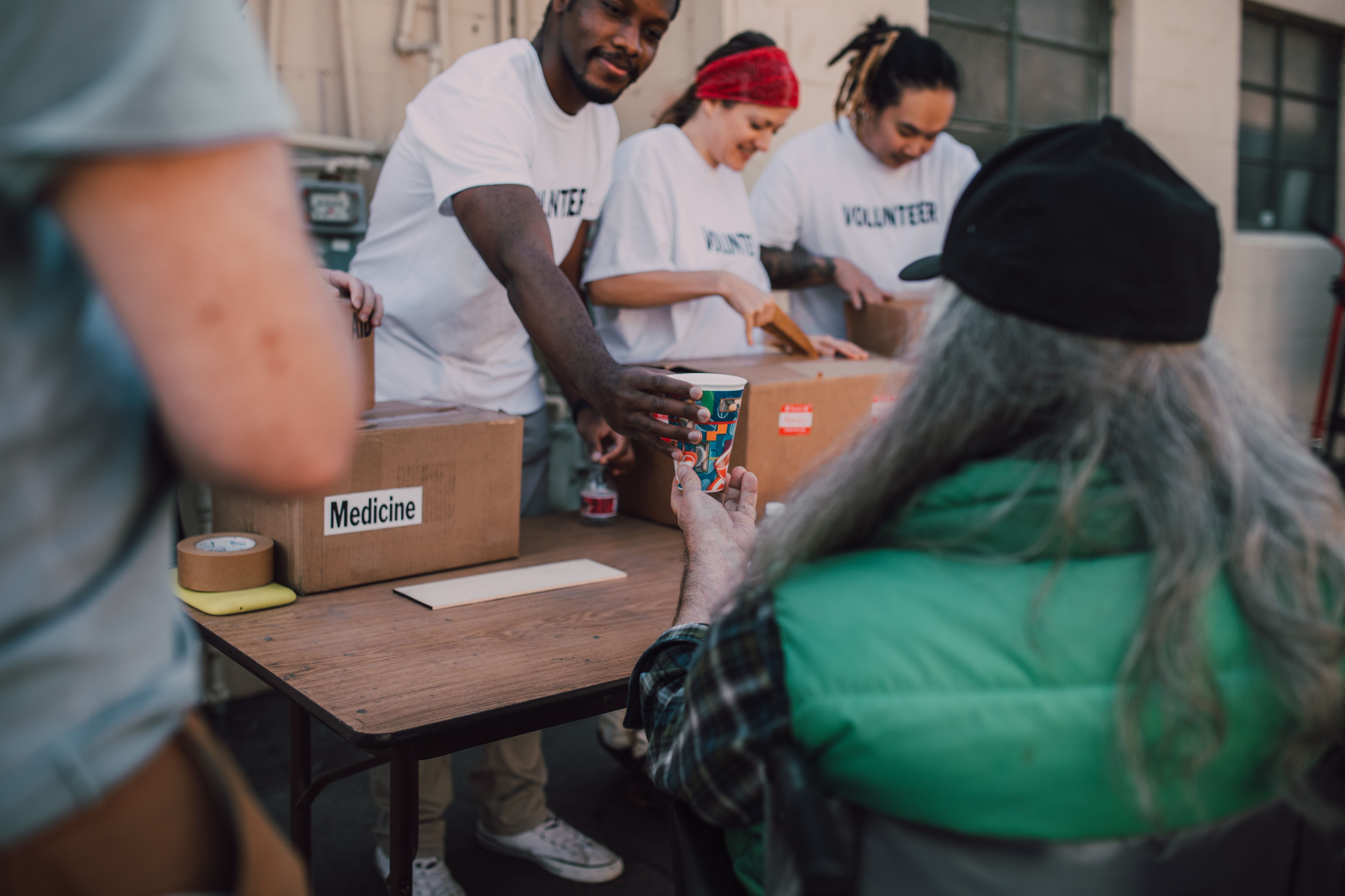 Volunteers handing out donations and support at a community event, illustrating measurable community impact.