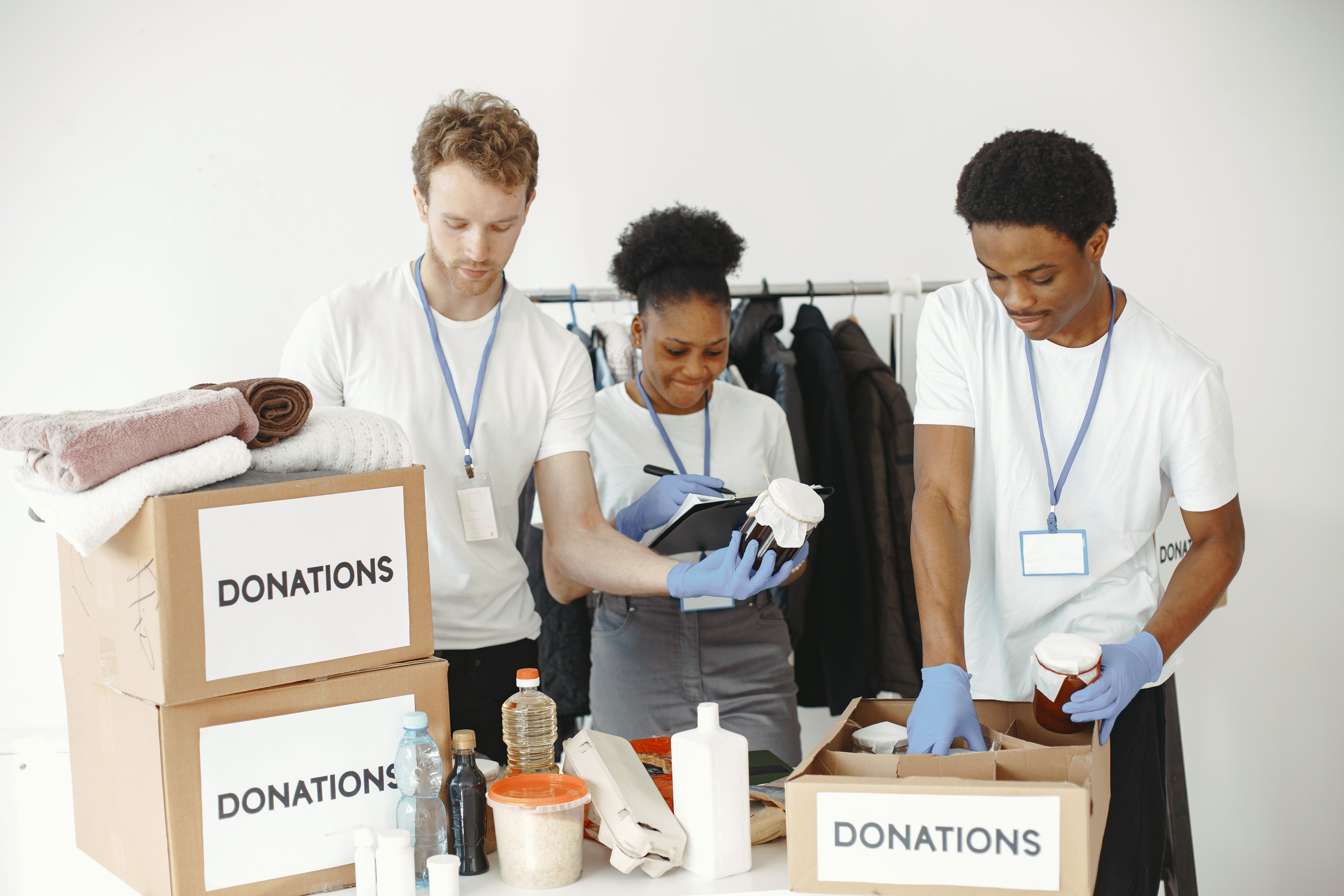 Volunteers organizing donation boxes with food and clothing in a community center.